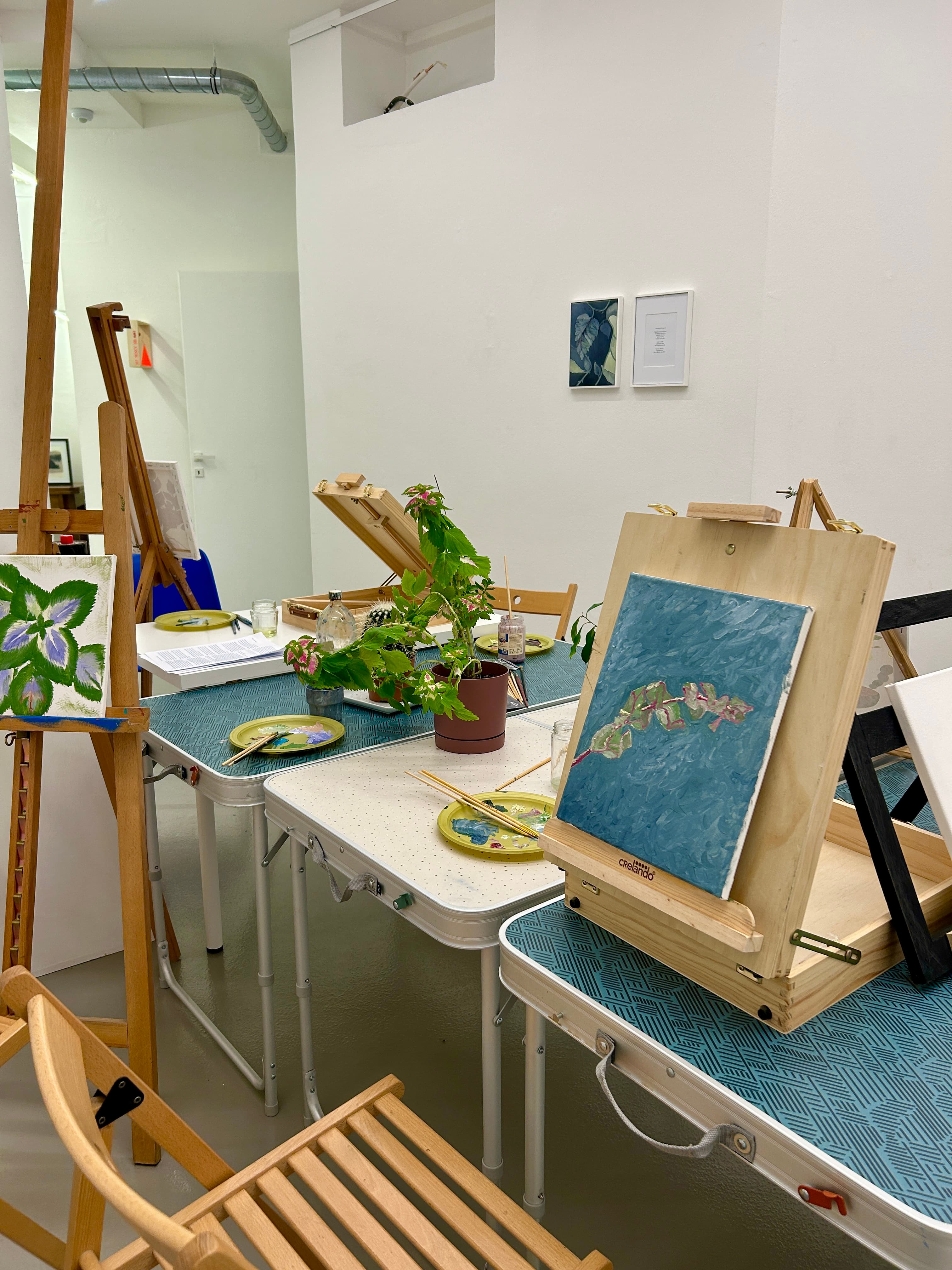 Tele dipinte e piante sui tavoli del laboratorio di pittura in galleria