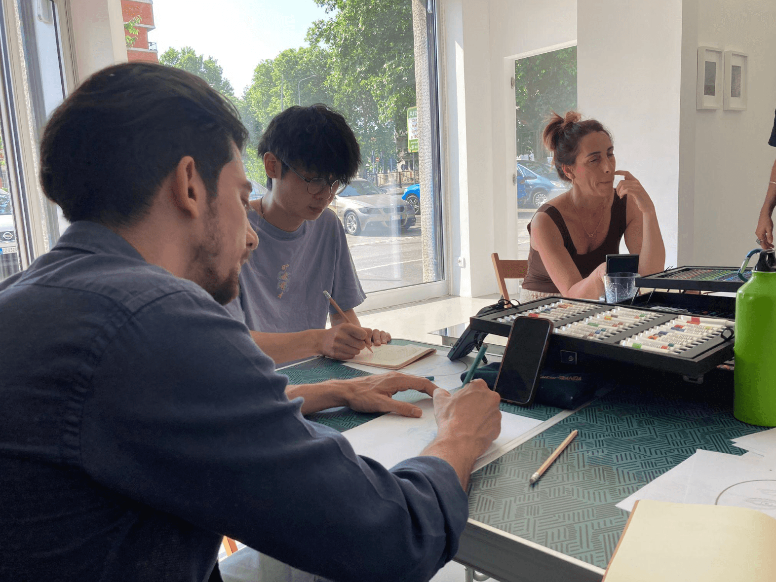 Partecipanti raccolti intorno a un tavolo durante un laboratorio di disegno dal vivo